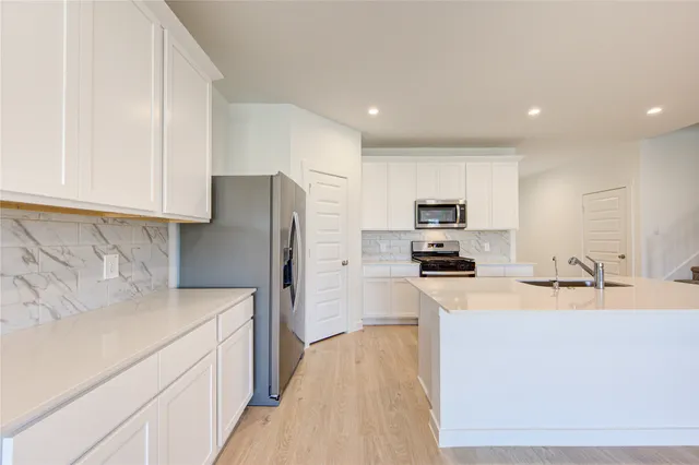 a kitchen with stainless steel appliances a refrigerator stove and sink