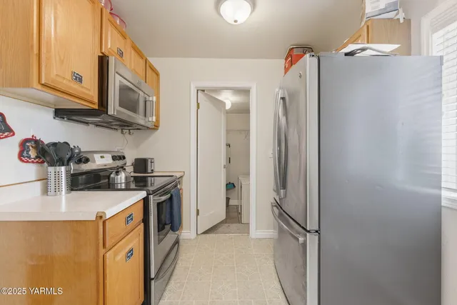 a kitchen with stainless steel appliances granite countertop a refrigerator and a sink