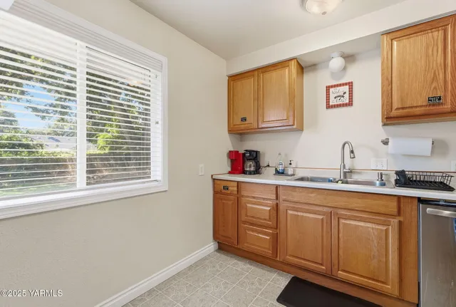a kitchen with granite countertop a sink cabinets and window
