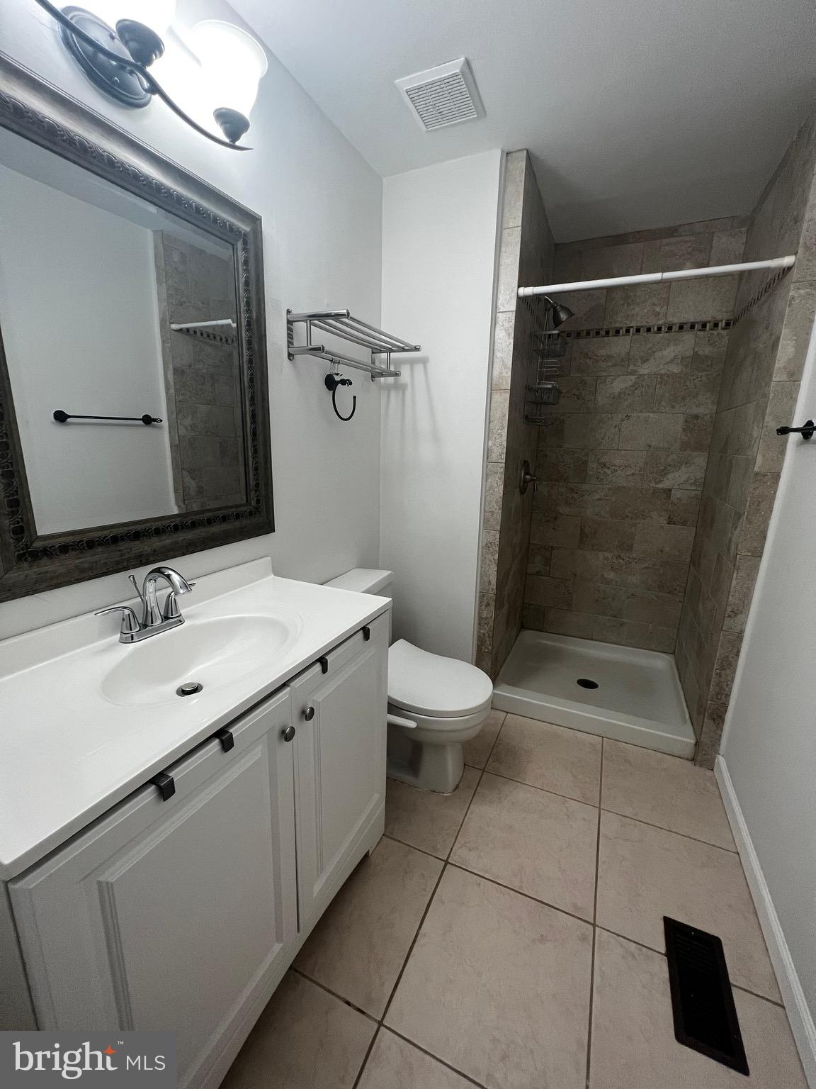 7148 Lasting Light Way Columbia, MD 21045 - Photo 18 of 20 a bathroom with a double vanity sink toilet and shower