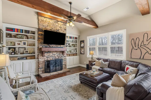 a living room with furniture a flat screen tv and a fireplace