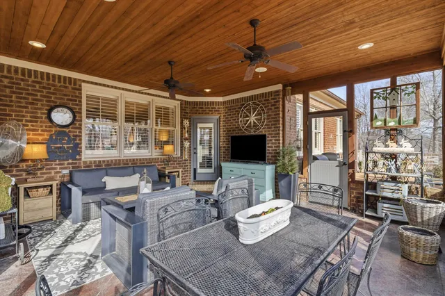 a living room with furniture a flat screen tv and a large window