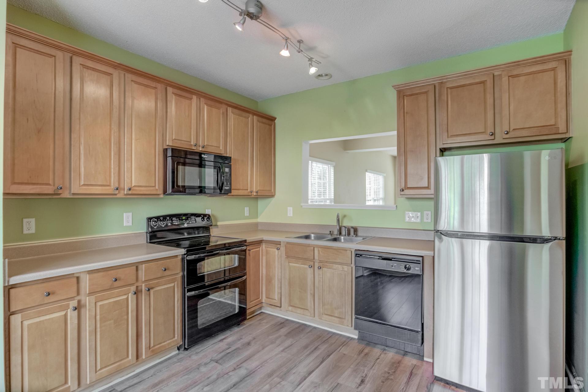 508 Erie Road Raleigh, NC 27610 - Photo 9 of 33 a kitchen with a sink white cabinets and stainless steel appliances