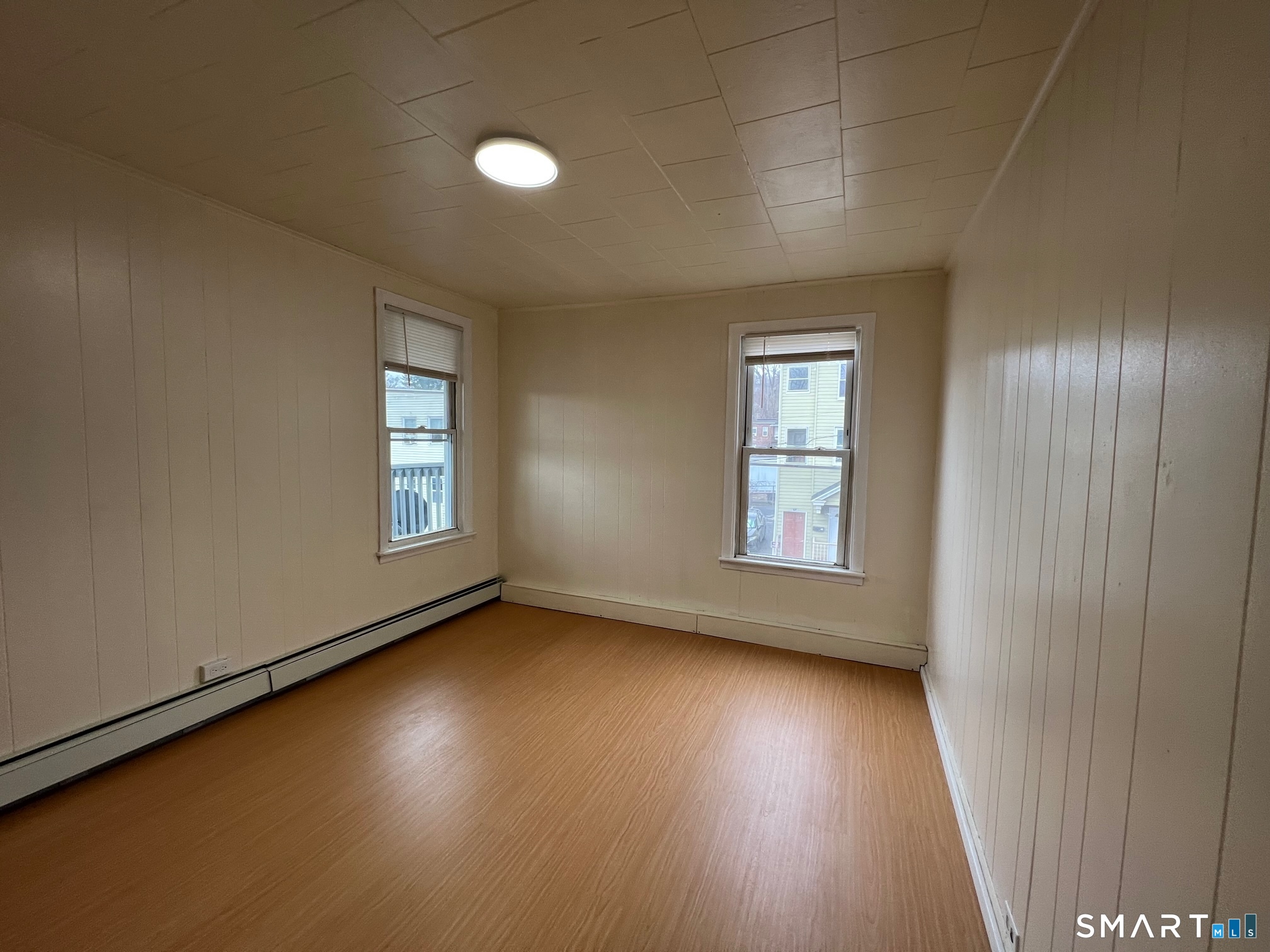 62 North Leonard Street Waterbury, CT 06708 - Photo 8 of 13 an empty room with wooden floor and windows