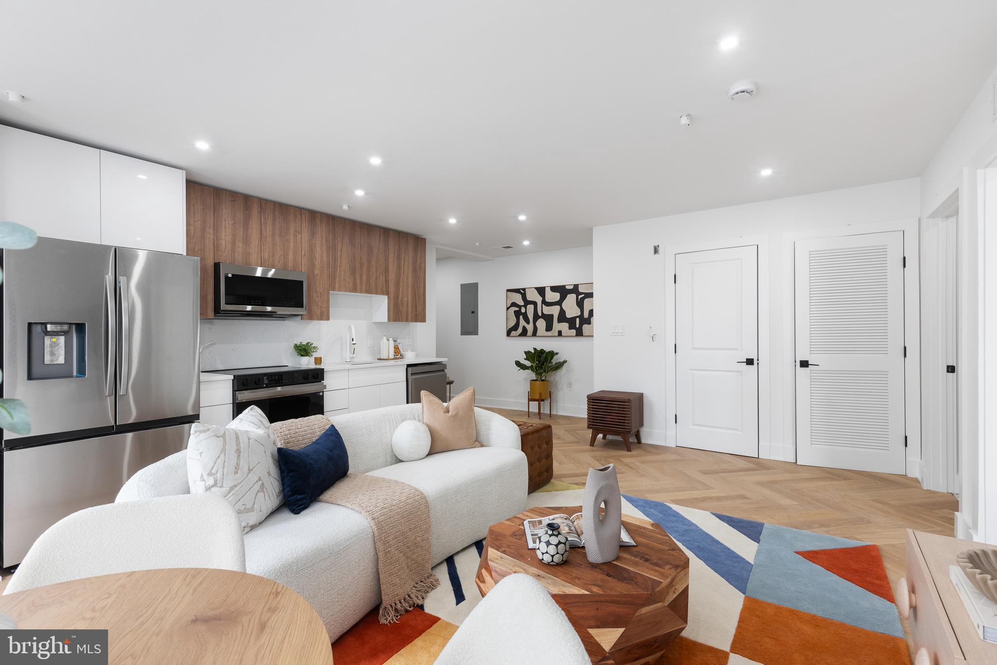 1124 Florida Street Northeast, Unit 203 Washington, DC 20002 - Photo 2 of 18 a living room with furniture a kitchen view and a refrigerator