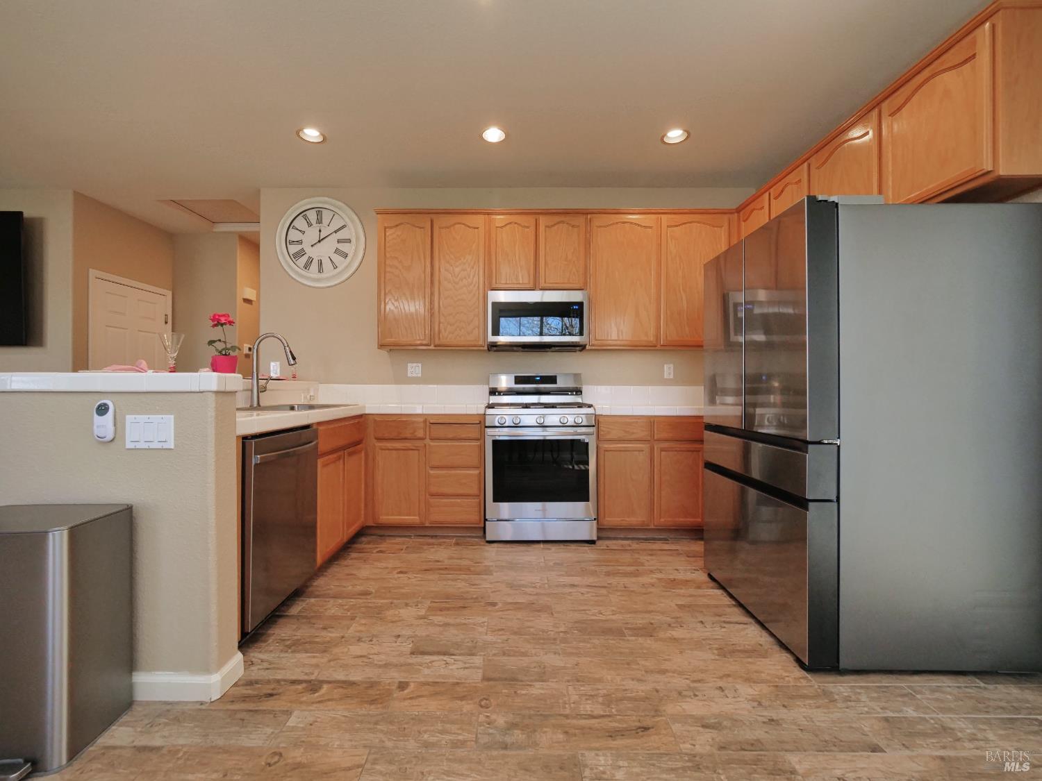 773 Turnberry Terrace Rio Vista, CA 94571 - Photo 13 of 52 a kitchen with stainless steel appliances granite countertop a stove top oven a refrigerator and a sink with wooden cabinets