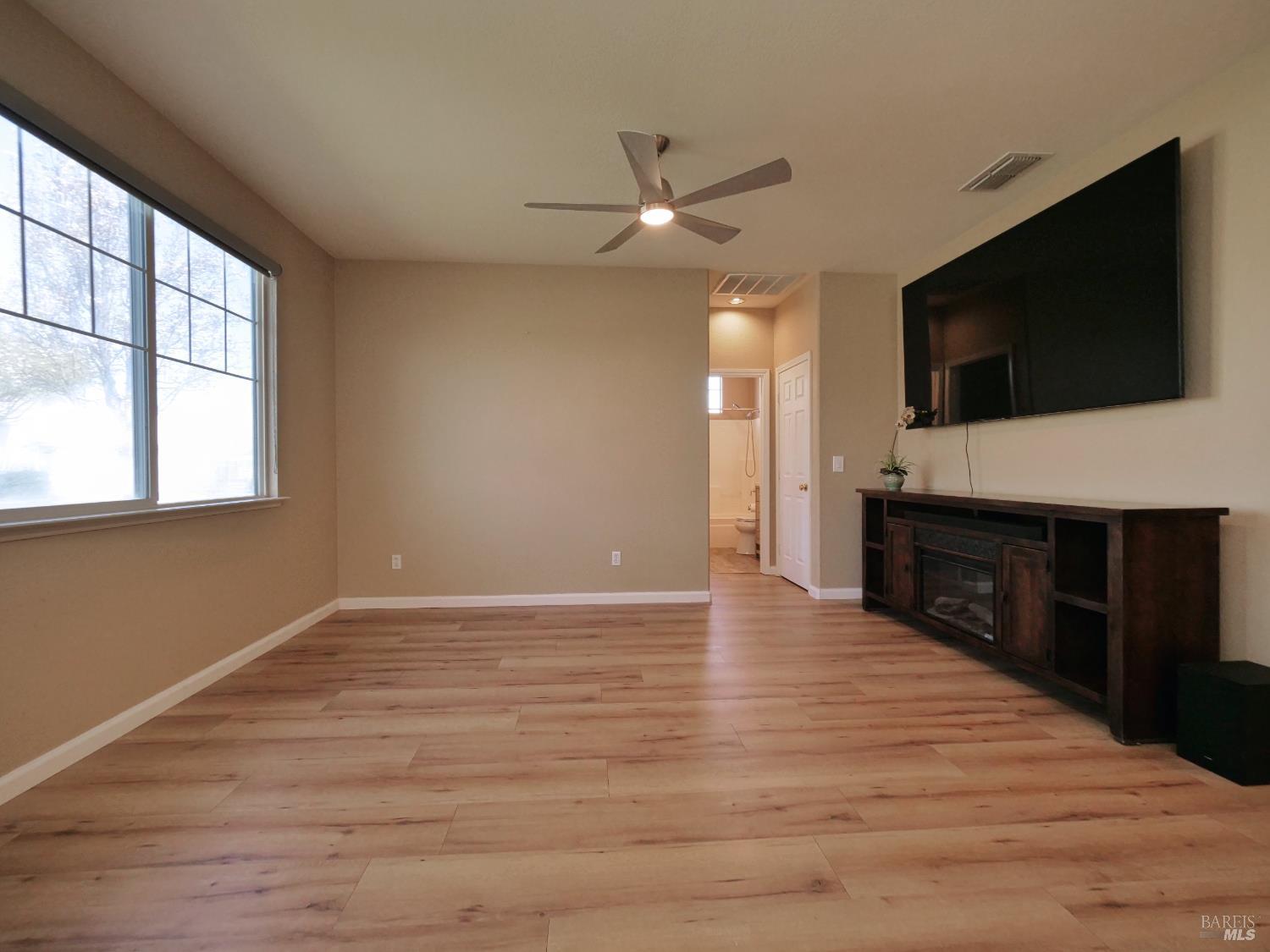 773 Turnberry Terrace Rio Vista, CA 94571 - Photo 6 of 52 a view of a livingroom with a flat screen tv wooden floor and a ceiling fan