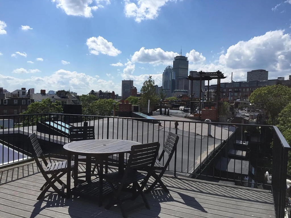 11 Milford Street, Unit 4 Boston, MA 02118 - Photo 22 of 22 a view of a roof deck with dining table and chairs