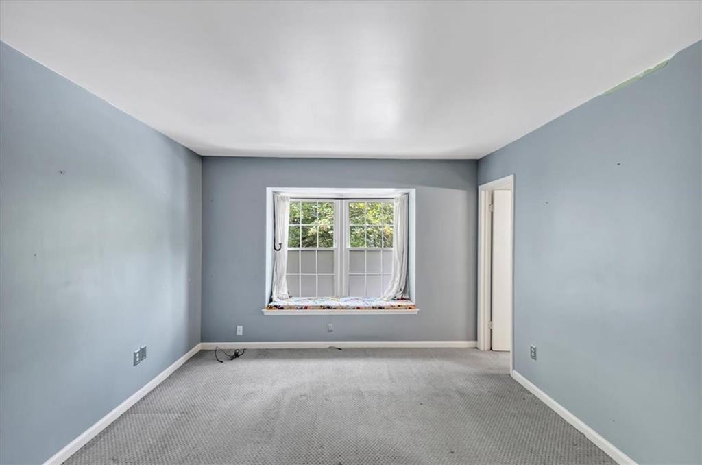 144 Woodmere Square Northwest Atlanta, GA 30327 - Photo 15 of 43 an empty room with wooden floor and windows