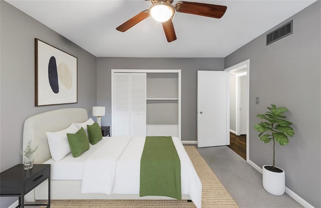 144 Woodmere Square Northwest Atlanta, GA 30327 - Photo 21 of 43 a bedroom with a bed potted plant with the wooden floor