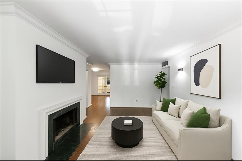 144 Woodmere Square Northwest Atlanta, GA 30327 - Photo 7 of 43 a living room with furniture a flat screen tv and a fireplace