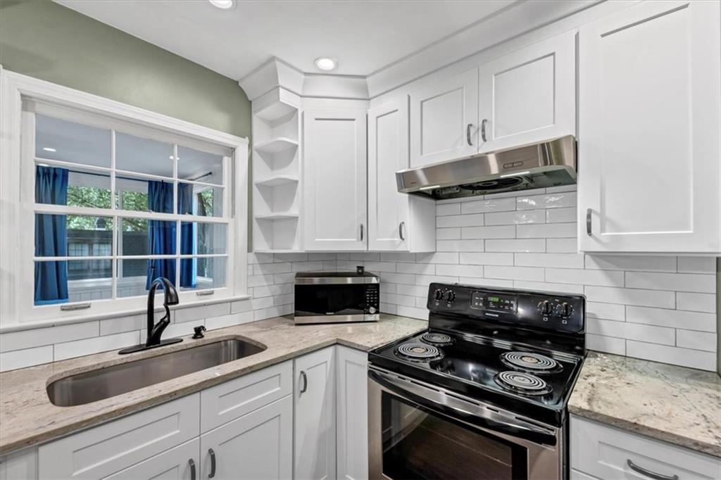 144 Woodmere Square Northwest Atlanta, GA 30327 - Photo 10 of 43 a kitchen with granite countertop a sink stainless steel appliances and cabinets