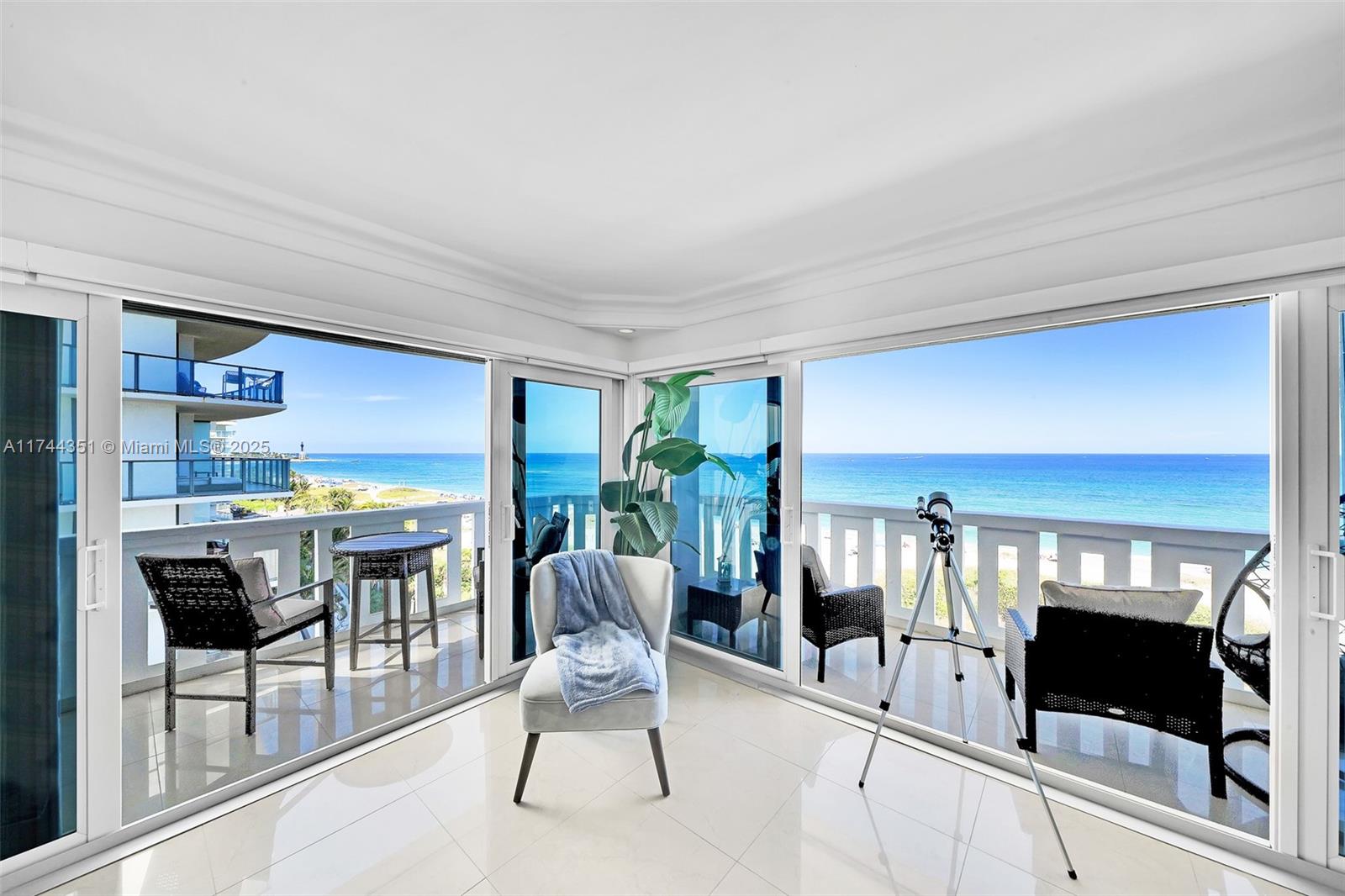 a living room with furniture a flat screen tv and a floor to ceiling window
