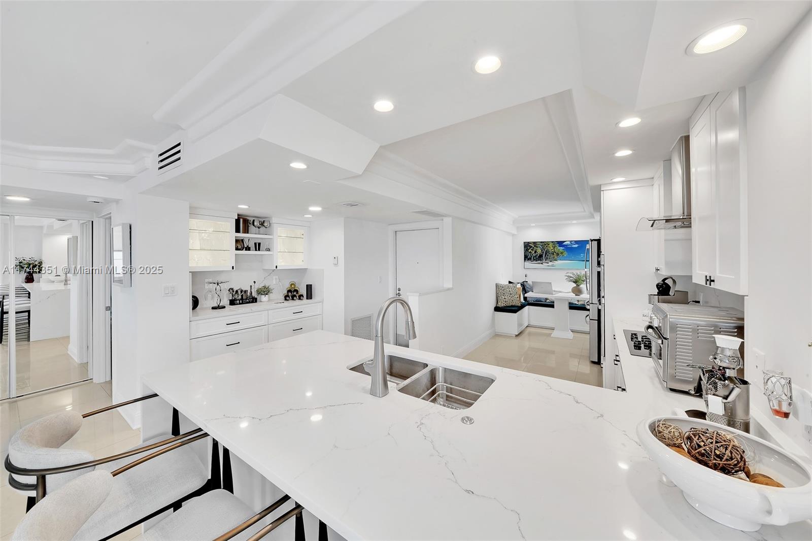 1012 North Ocean Boulevard, Unit 701 Pompano Beach, FL 33062 - Photo 12 of 57 a kitchen with kitchen island a large counter top space appliances and cabinets