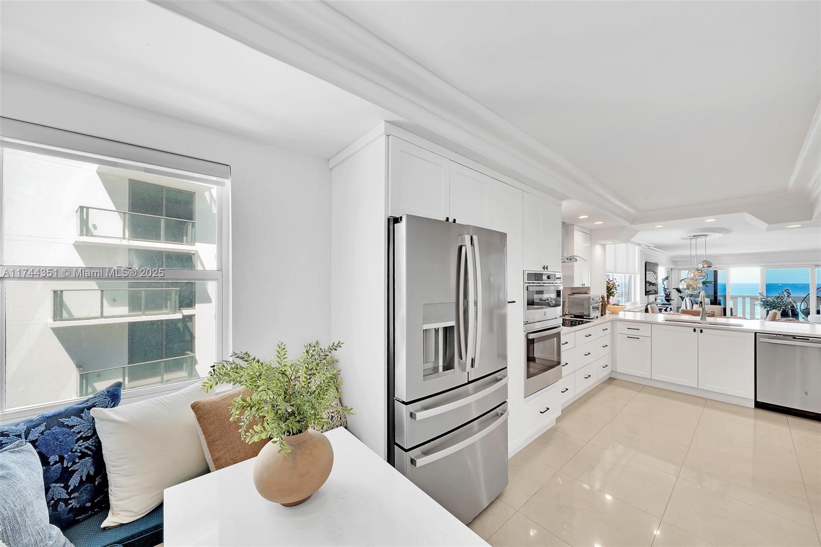 1012 North Ocean Boulevard, Unit 701 Pompano Beach, FL 33062 - Photo 15 of 57 a kitchen with white cabinets and stainless steel appliances