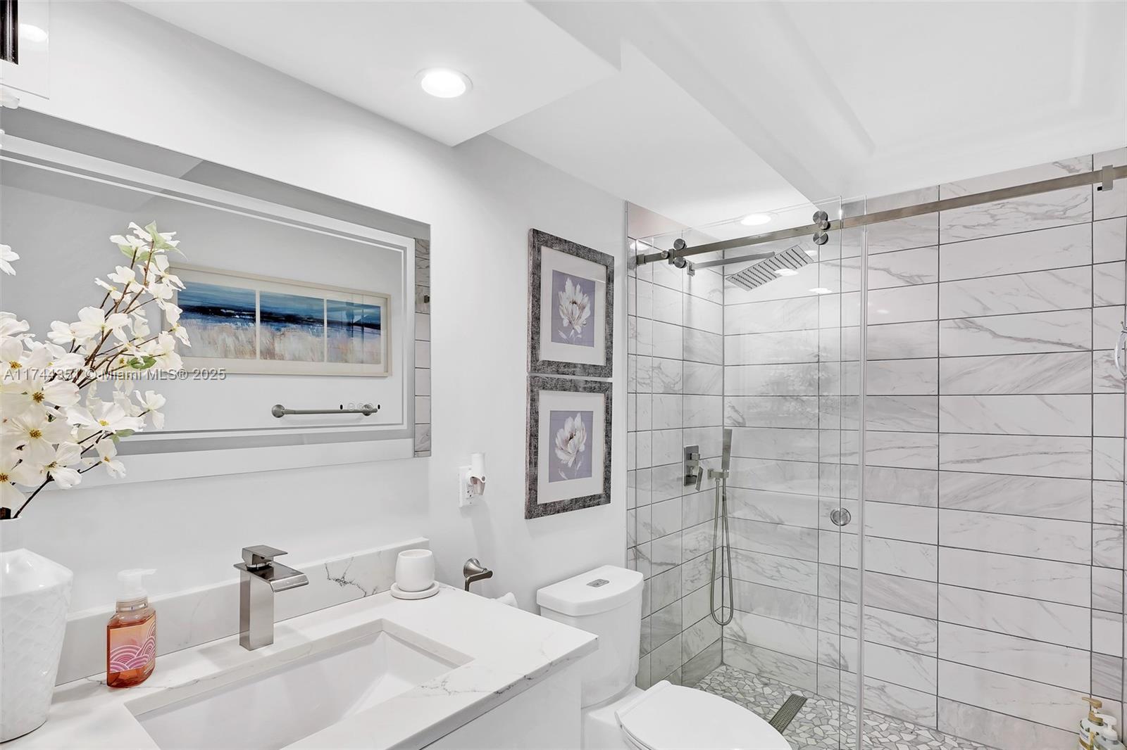 1012 North Ocean Boulevard, Unit 701 Pompano Beach, FL 33062 - Photo 21 of 57 a bathroom with a sink toilet and shower