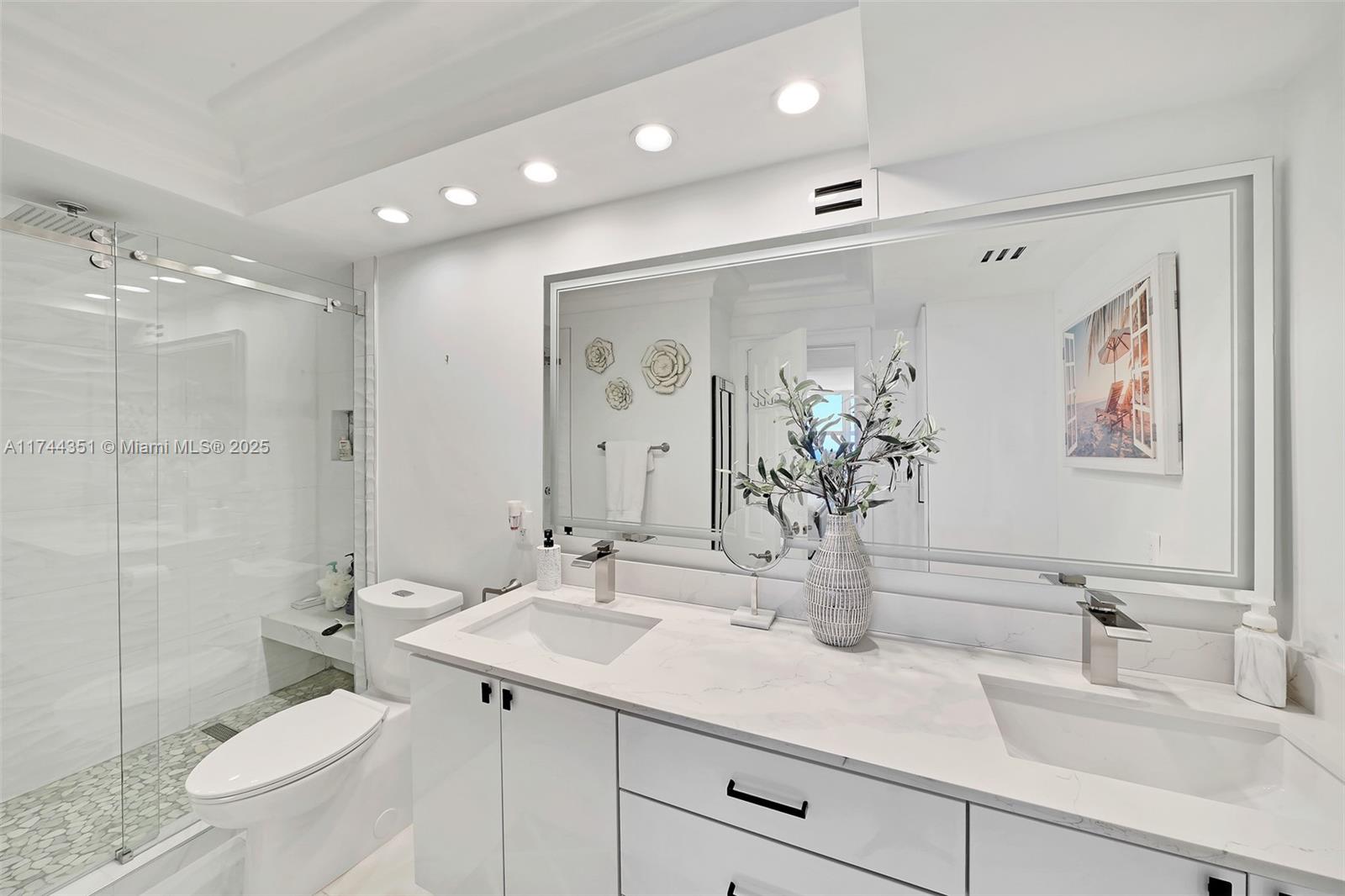 1012 North Ocean Boulevard, Unit 701 Pompano Beach, FL 33062 - Photo 32 of 57 a bathroom with a double vanity sink mirror and toilet