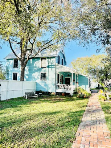 a view of a house with a big yard and large trees