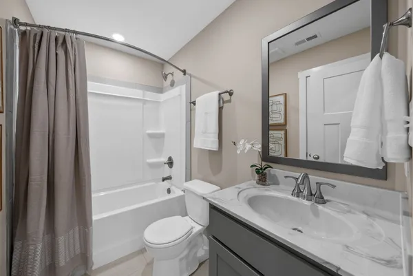 a bathroom with a sink a toilet and a large mirror