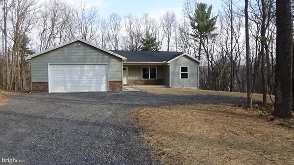 a view of house with a yard and large trees