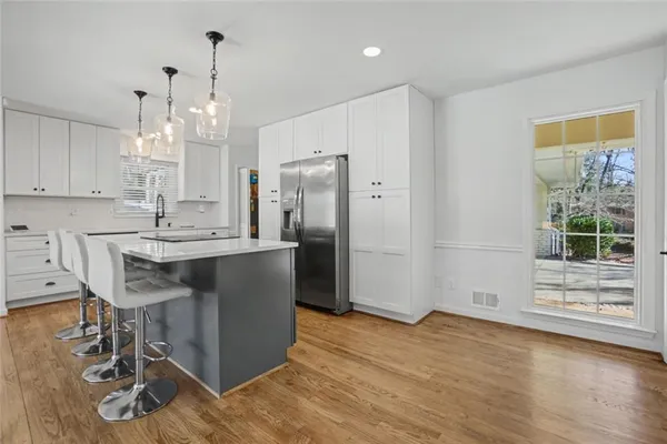 a kitchen with kitchen island granite countertop a sink cabinets and wooden floor