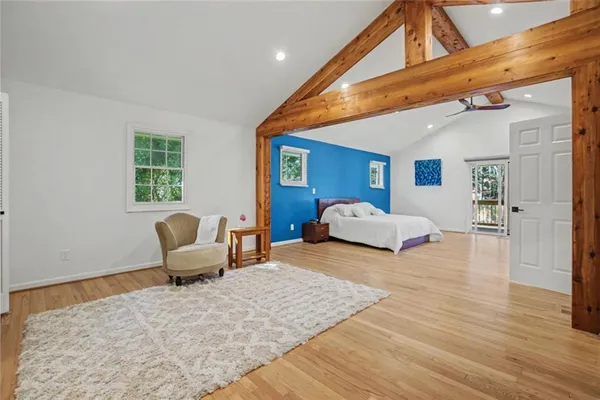 a bedroom with a large bed and wooden floor