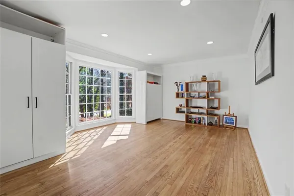 a dining room with furniture a large window and wooden floor