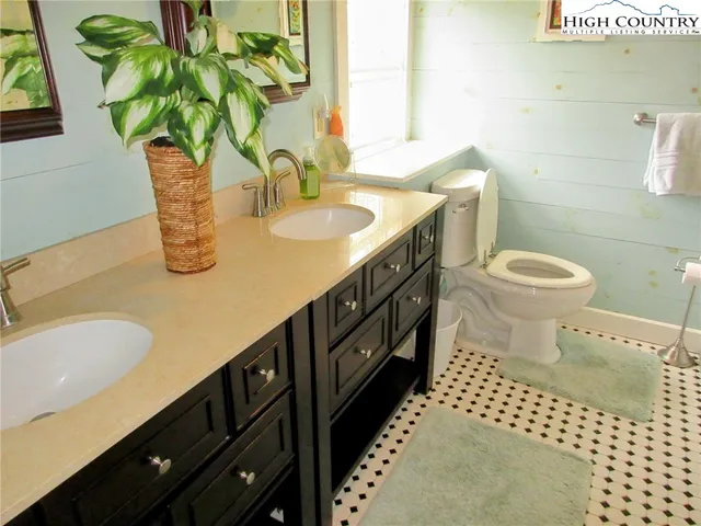 a bathroom with a sink a toilet and a mirror