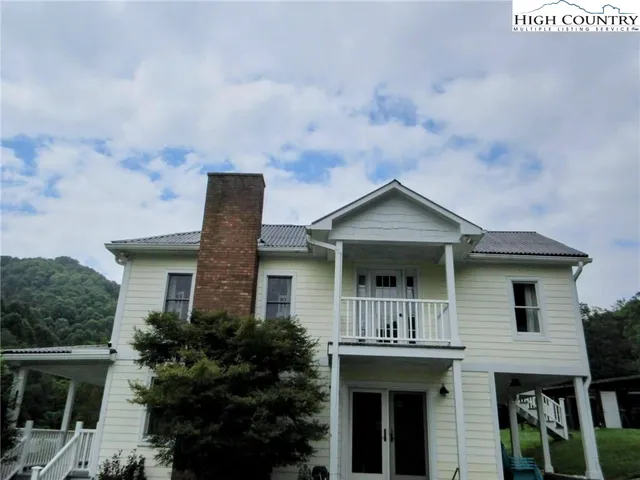 a front view of house with yard and trees around