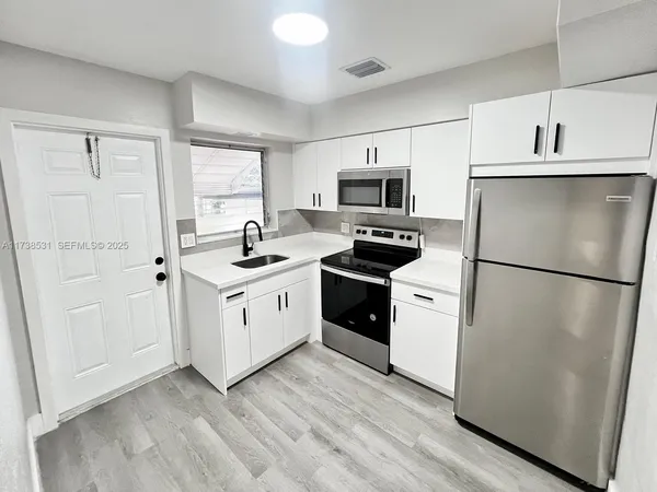 a kitchen with a refrigerator stove and sink