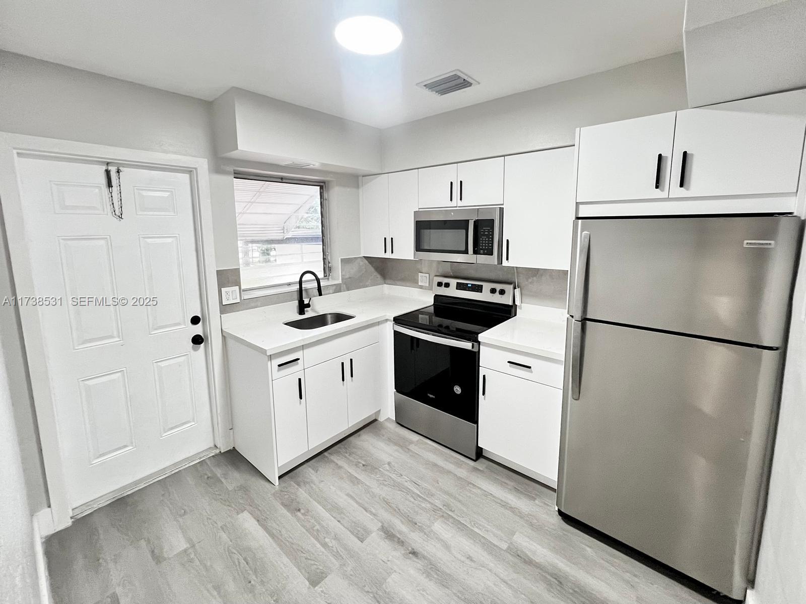 226 Southwest 6th Street, Unit A Dania Beach, FL 33004 - Photo 1 of 14 a kitchen with a refrigerator stove and sink