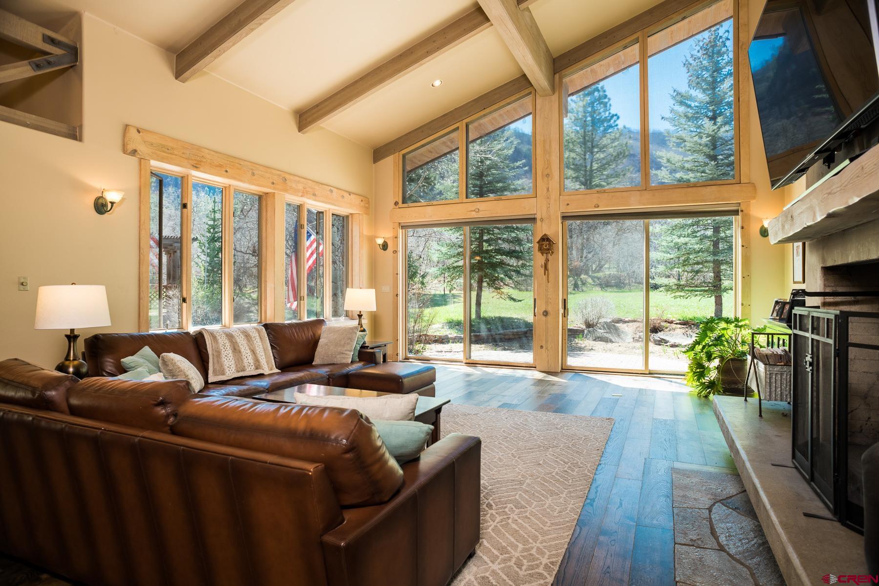 47 Mason Cabin Road Durango, CO 81301 - Photo 11 of 35 a living room with furniture large windows and a flat screen tv