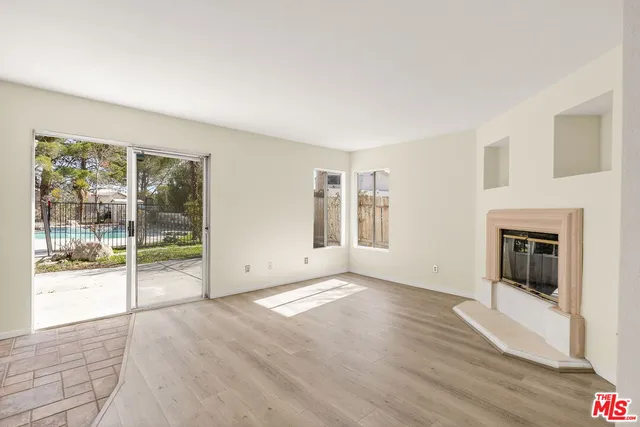 a view of a livingroom with wooden floor and a kitchen