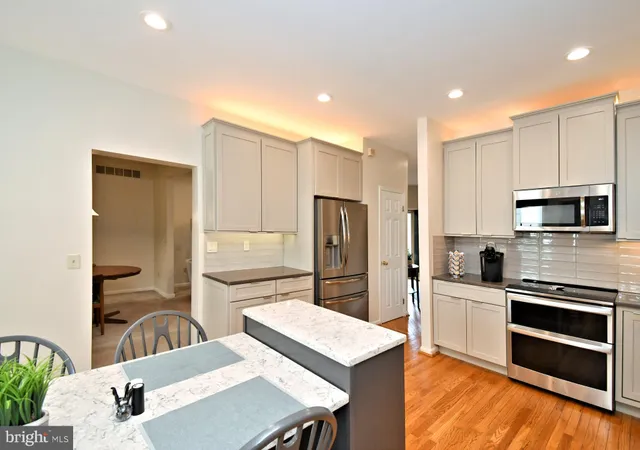 a kitchen with stainless steel appliances a refrigerator and a stove top oven