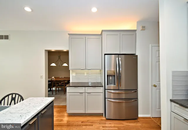 a kitchen with stainless steel appliances granite countertop a refrigerator and a sink