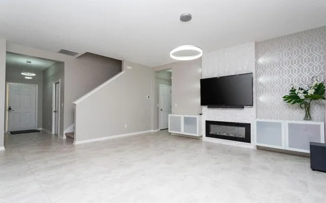 an empty room with furniture and a flat screen tv