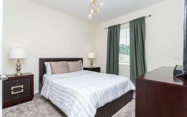 a bedroom with a bed and a dresser next to a window