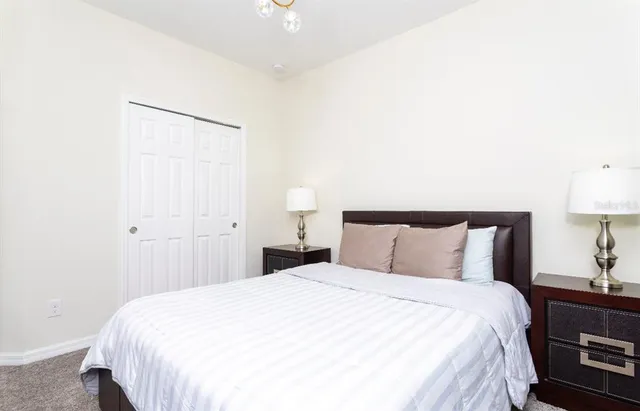 a bedroom with a bed and a lamp on dresser