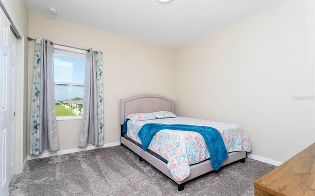 a bed sitting in a bedroom next to a window