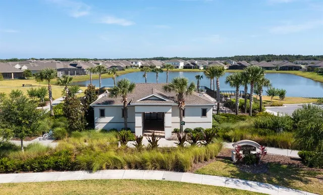 an aerial view of a house with a yard and lake view