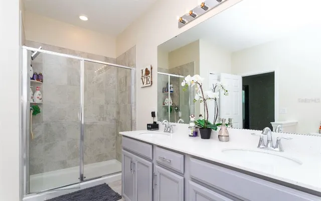 a bathroom with a double vanity sink mirror and shower
