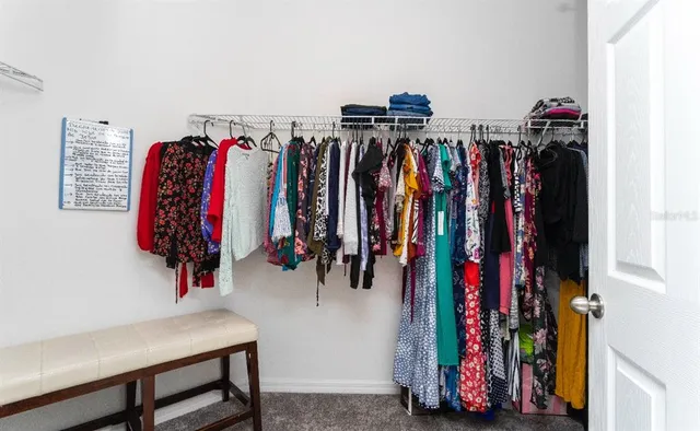 a view of walk in closet with clothes