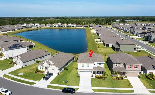 an aerial view of residential houses with outdoor space and ocean view