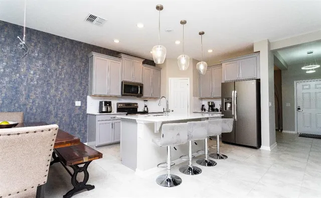 a kitchen with stainless steel appliances kitchen island granite countertop a sink and a refrigerator
