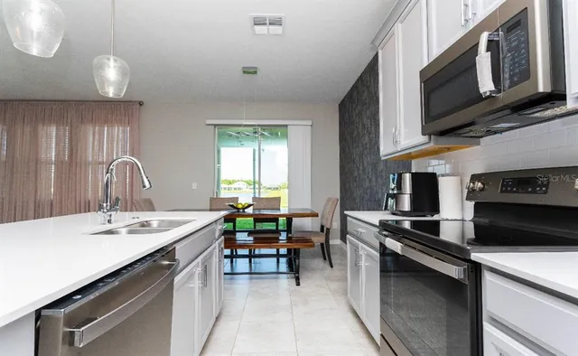 a kitchen with a sink stove and cabinets