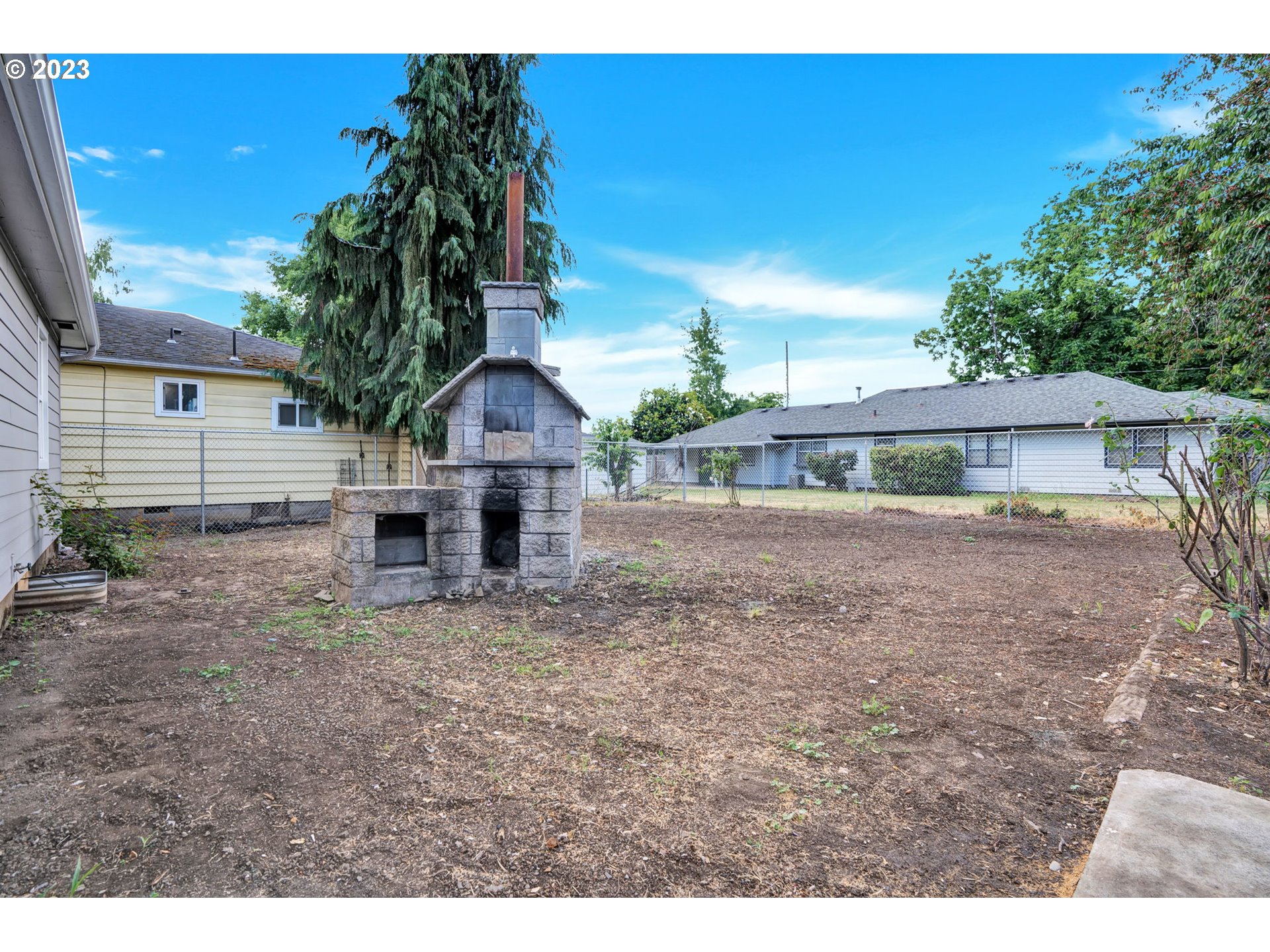 840 High Street Woodburn, OR 97071 - Photo 16 of 18 a view of house with backyard and a tree