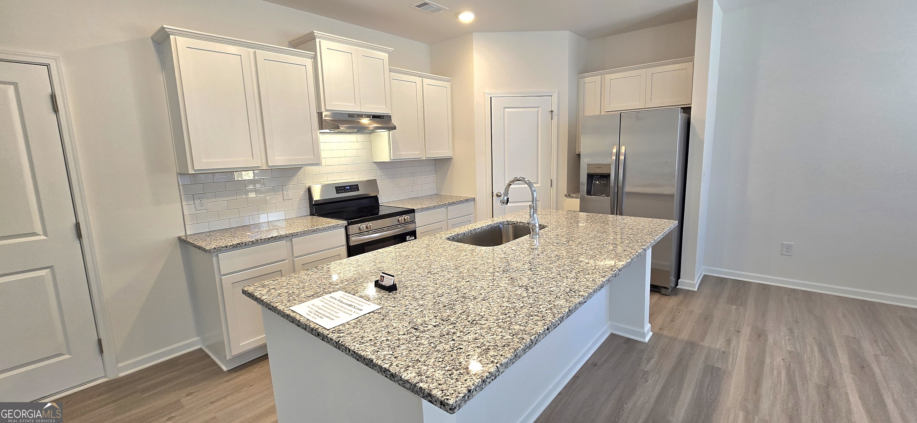 34 Russet Way Newnan, GA 30263 - Photo 11 of 38 a kitchen with kitchen island granite countertop a sink stove and refrigerator