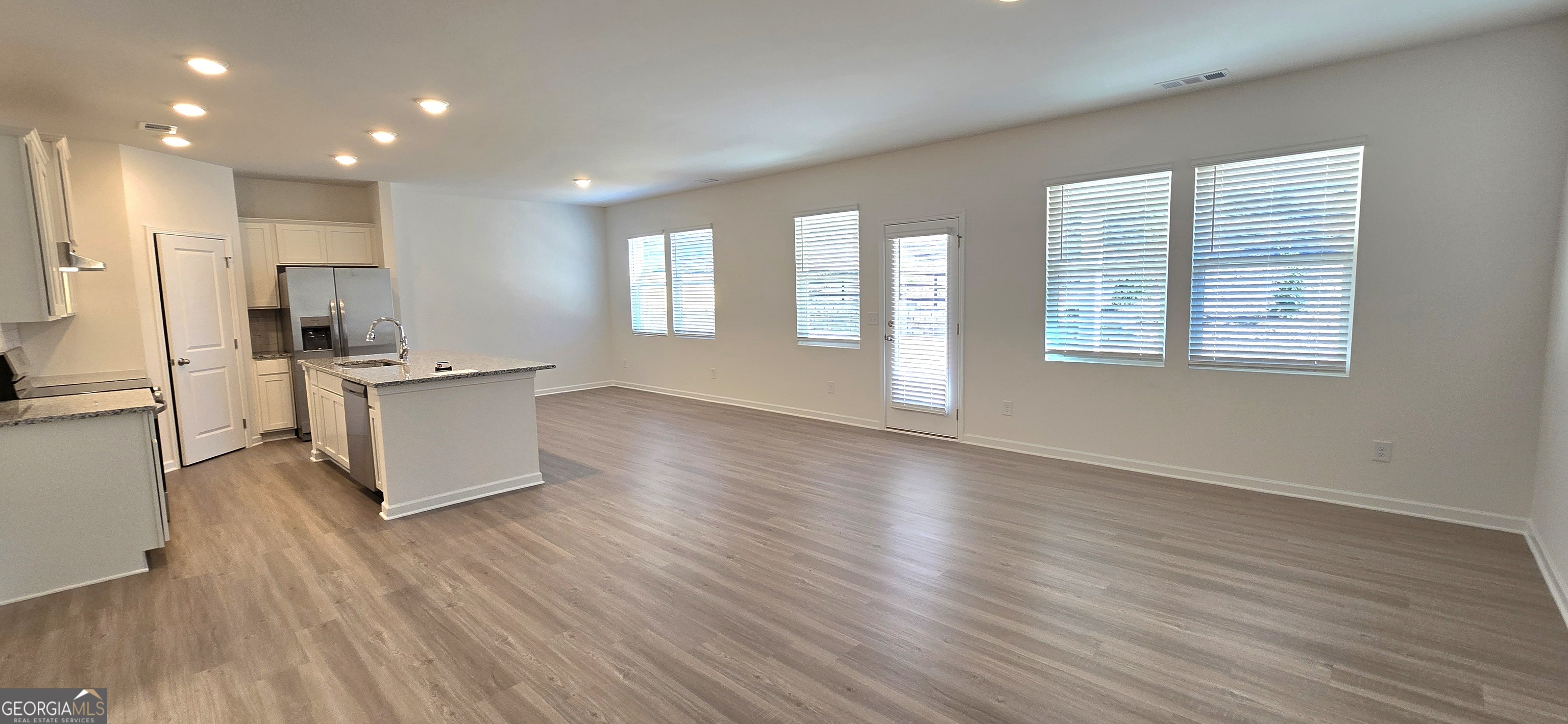 34 Russet Way Newnan, GA 30263 - Photo 5 of 38 a living room with stainless steel appliances kitchen island hardwood floor and a large window