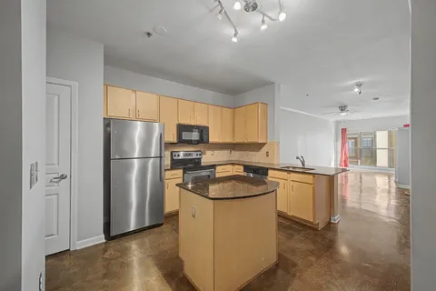 a kitchen with stainless steel appliances granite countertop a sink a stove a microwave and a refrigerator