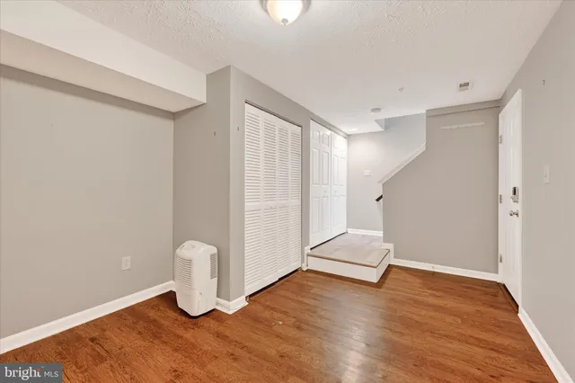 an empty room with wooden floor and white walls